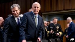 El Director del FBI, Christopher Wray (izq.), y el Director de Inteligencia Nacional, Dan Coats (segundo desde la izq.), llegan a la audiencia del Comité Selecto de Inteligencia sobre amenazas mundiales, el martes 13 de febrero de 2018 en Washington. (AP Photo / Andrew Harnik)