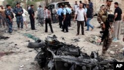 Security forces inspect the scene of a car bomb attack in Basra, 340 miles (550 kilometers) southeast of Baghdad, Iraq, Jul. 14, 2013.