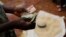 A Malawian trader counts money as he sells maize near the capital Lilongwe, Malawi, Feb. 1, 2016. 