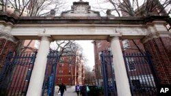 FILE - People walk through the gates leading to Harvard Yard, at Harvard University in Cambridge, Massachusetts, Dec. 13, 2018.