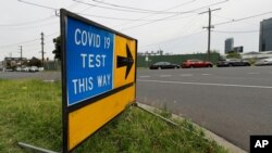 A sign leading to a COVID-19 testing station in Melbourne, Australia, Thursday, Feb. 4, 2021. All competition at six Australian Open tuneup events scheduled for Thursday was called off after a worker at one of the tournaments' Melbourne quarantine…