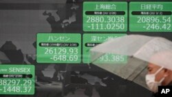 A man walks past an electronic stock board showing Japan and other countries' index in Tokyo, March 2, 2020, with mainland Chinese indexes gaining 3%.