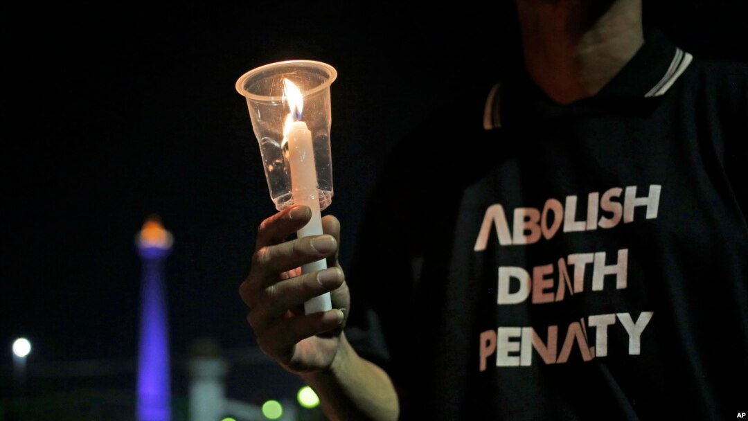 Seorang aktivis memegang lilin dalam aksi protes menentang hukuman mati di luat Istana Presiden, Jakarta, 28 Juli 2016. (Foto:ilustrasi/AP Photo/Dita Alangkara)