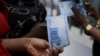 FILE - A person holds a new 1000 Naira note as the Central Bank of Nigeria releases the notes to the public through the banks in Abuja, Nigeria, Dec. 15, 2022. 