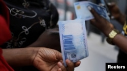 FILE - A person holds a new 1000 Naira note as the Central Bank of Nigeria releases the notes to the public through the banks in Abuja, Nigeria, Dec. 15, 2022. 