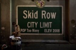 FILE - A homeless man takes food from a trash can in Los Angeles' Skid Row area, home to the nation's largest concentration of homeless people, Oct. 28, 2017.