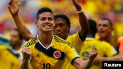 Los colombianos James Rodríguez y Juan Cuadrado (en segundo plano) celebran el triunfo frente a Costa de Marfil.