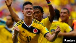 Los colombianos James Rodríguez y Juan Cuadrado (en segundo plano) celebran el triunfo frente a Costa de Marfil.