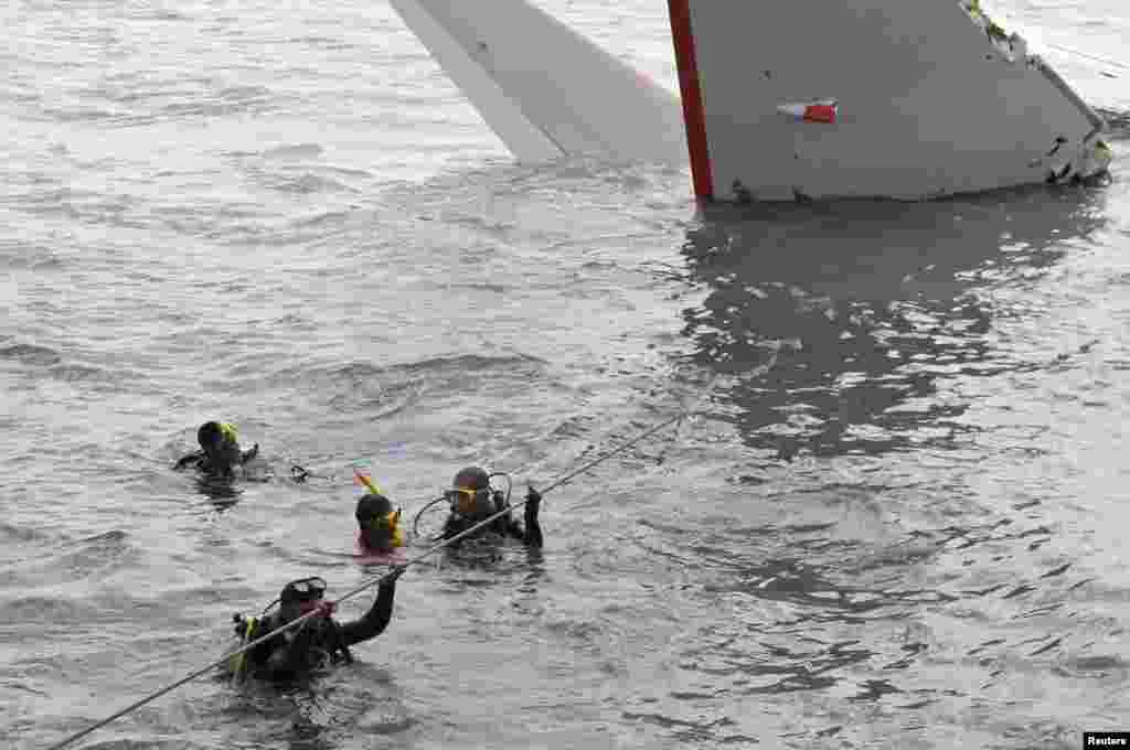 Seorang tim penyelamat berenang dekat bangkai pesawat Lion Air yang tergelincir ke laut dekat Bandar Udara Ngurah Rai, Bali (15/4).