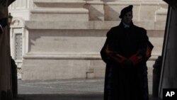 FILE - A Vatican Swiss guard stands on guard at the Vatican, Feb. 12, 2012. Money laundering at the Vatican bank. Corruption in the awarding of Vatican contracts. Switzerland's government adopted new rules to clamp down on money laundering as the country seeks to cast off its reputation as a haven for hidden cash.