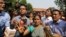 FILE - Journalists crowd around Asha Devi, mother of the victim of the fatal 2012 gang rape on a moving bus, after the Supreme Court verdict in the case, in New Delhi, India, May 5, 2017. 