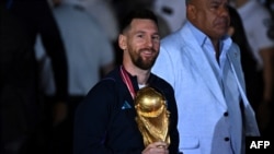 Foto de archivo: El argentino Lionel Messi sostiene el Trofeo de la Copa Mundial de la FIFA a su llegada al Aeropuerto Internacional de Ezeiza, provincia de Buenos Aires, Argentina, el 20 de diciembre de 2022. (Foto de Luis ROBAYO / AFP) 