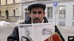 Vladimir Linderman, co-chairman of the Mother Tongue movement and a leader of Latvia's Russian community, holds a leaflet in downtown Riga, February 1, 2012.