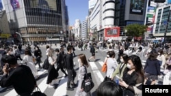 Pejalan kaki mengenakan masker saat melintasi persimpangan Shibuya di tengah pandemi COVID-19 di Tokyo, Jepang, 23 April 2021. (Kyodo via REUTERS)
