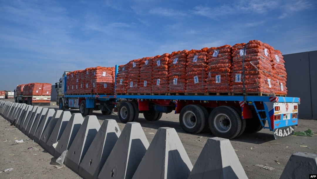 Truk-truk bermuatan bantuan menunggu untuk menyeberang ke Gaza dari sisi Mesir di perbatasan dengan kota Rafah, Jalur Gaza, Minggu 19 Januari 2025.