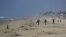Two surfers walk to the water, May 1, 2020, in Huntington Beach, Calif. California Gov. Gavin Newsom ordered all Orange County beaches closed starting Friday after thousands gathered last weekend in Huntington Beach and Newport Beach.