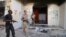 Libyan military guards check one of the U.S. Consulate's burnt out buildings during a visit by Libyan President Mohammed el-Megarif, not shown, to the U.S. Consulate, Sept 14, 2012.