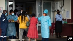 A health worker checks the temperature of an elderly patient at the emergency entrance of the Steve Biko Academic Hospital in Pretoria, South Africa, Jan. 11, 2021.