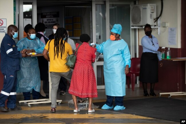 A health worker checks the temperature of an elderly patient at the emergency entrance of the Steve Biko Academic Hospital in Pretoria, South Africa, Jan. 11, 2021.