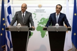 Greek foreign minister Nikos Dendias, left, and Cyprus' foreign minister Nikos Christodoulides talk during a press conference after their meeting at the Cyprus' foreign ministry in capital Nicosia, Cyprus, Aug. 18, 2020.