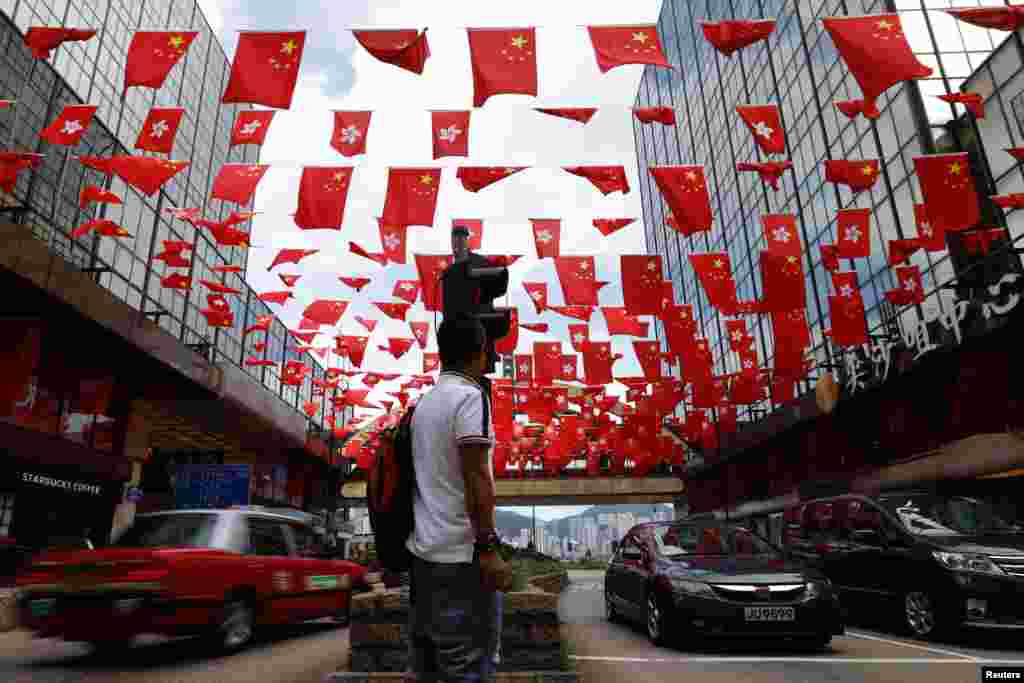 香港移交中国20周年前夕，香港街道上空飘扬着中国国旗和香港区旗