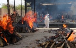 Multiple funeral pyres of people who died of COVID-19 burn at the Ghazipur crematorium in New Delhi, India, May 13, 2021.