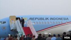 Presiden Joko Widodo di atas tangga pesawat kepresidenan di Bandara Halim Perdana Kusuma (24/10). (VOA/Andylala Waluyo)