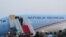 Presiden Joko Widodo di atas tangga pesawat kepresidenan di Bandara Halim Perdana Kusuma (24/10). (VOA/Andylala Waluyo)