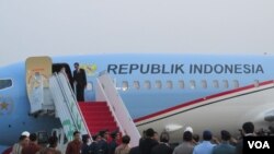 Presiden Joko Widodo di atas tangga pesawat kepresidenan di Bandara Halim Perdana Kusuma (24/10). (VOA/Andylala Waluyo)