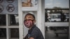 A boy wears a face mask as a preventive measure against the spread of the COVID-19 coronavirus outside Makro in Soweto, Johannesburg, South Africa, on March 24, 2020.