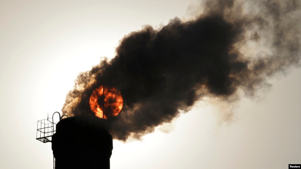 FILE - The sun is seen behind smoke billowing from a chimney of a heating plant in Taiyuan, Shanxi province.