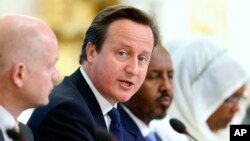 Britain's Prime Minister David Cameron speaks as Britain's Foreign Secretary William Hague, left, and Somali President Hassan Sheikh Mohamud listen at the Somalia conference in London, May 7, 2013.