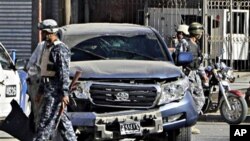 ژماره‌یه‌ک له‌ هێزه‌کانی ئاسایشی عێراق پاسه‌وانی له‌ شوێنی یه‌ک له‌ ته‌قینه‌وه‌کانی به‌غدا ده‌که‌ن، شه‌ممه‌ 4 ی دوازده‌ی 2010