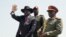 FILE - South Sudan's President Salva Kiir, left, accompanied by army chief of staff Paul Malong Awan, waves during an independence day ceremony in the capital Juba, South Sudan, July 9, 2015. 
