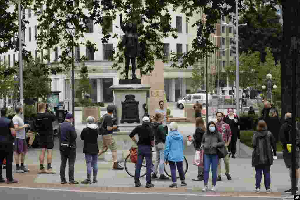 People look at a statue of a Black Lives Matter protester by British artist Marc Quinn erected in the spot once occupied by the statue of a slave trader in the English city of Bristol.&nbsp;