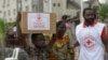 FILE - A child with his mother from Makoko slum carries their food parcel distributed by the Nigerian Red Cross, provided for those under coronavirus-related movement restrictions, in Lagos, Nigeria, April 25, 2020.