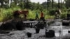 FILE - Men walk past an illegal refinery at the creeks of Bayelsa, Nigeria, on May 18, 2013. Nigerian security forces said on Dec. 1, 2024, they performed successful raids against oil thieves over the past week.