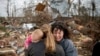Керол Дін, cправа, в обіймах Меган Андерсон та її 18-місячної дочки Меділін. Чоловік Дін загинув у результаті торнадо. Алабама, 4 березня 2019 року.