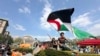 FILE - A demonstrator waves a flag on the Columbia University campus at a pro-Palestinian protest encampment, in New York, April 29, 2024.