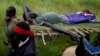 FILE - SPLA-IO (SPLA-In Opposition) rebels carry an injured rebel after an assault on government SPLA (Sudan People's Liberation Army) soldiers, on the road between Kaya and Yondu, South Sudan, Aug. 26, 2017.