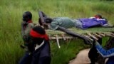 FILE - SPLA-IO (SPLA-In Opposition) rebels carry an injured rebel after an assault on government SPLA (Sudan People's Liberation Army) soldiers, on the road between Kaya and Yondu, South Sudan, August 26, 2017.