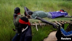 FILE - SPLA-IO (SPLA-In Opposition) rebels carry an injured rebel after an assault on government SPLA (Sudan People's Liberation Army) soldiers, on the road between Kaya and Yondu, South Sudan, August 26, 2017.