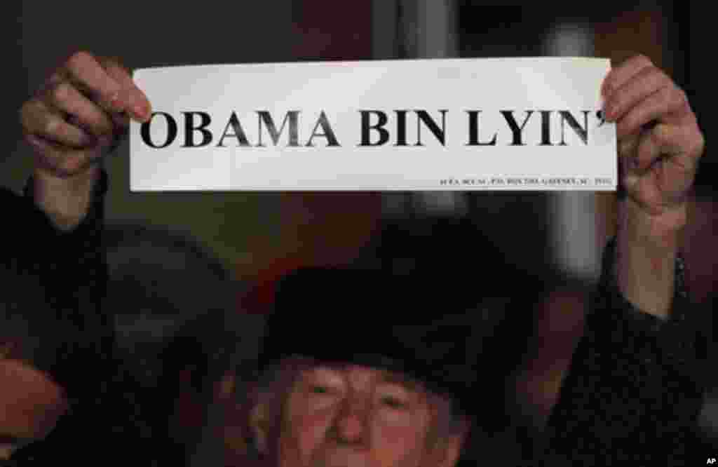 A man holds a sign reading "Obama Bin Lyin'" before a campaign rally with Republican presidential candidate and former Massachusetts Governor Mitt Romney in Columbia, South Carolina January 11, 2012.