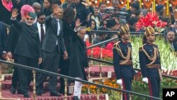 U.S. President Barack Obama, Indian Prime Minister Narendra Modi, left, and President Pranab Mukherjee wave to the crowd at the end of India’s annual Republic Day parade in New Delhi, India, Monday, Jan. 26, 2015. 