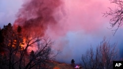 Las autoridades dijeron que el pequeño incendio forestal que arde en las montañas obligó a la gente a abandonar sus hogares y llenó el cielo de humo.