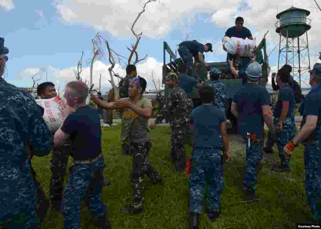 U.S. sailors work with Philippine armed forces members to transport relief supplies in Ormoc City, Philippines, Nov. 18, 2013. (U.S. Navy)