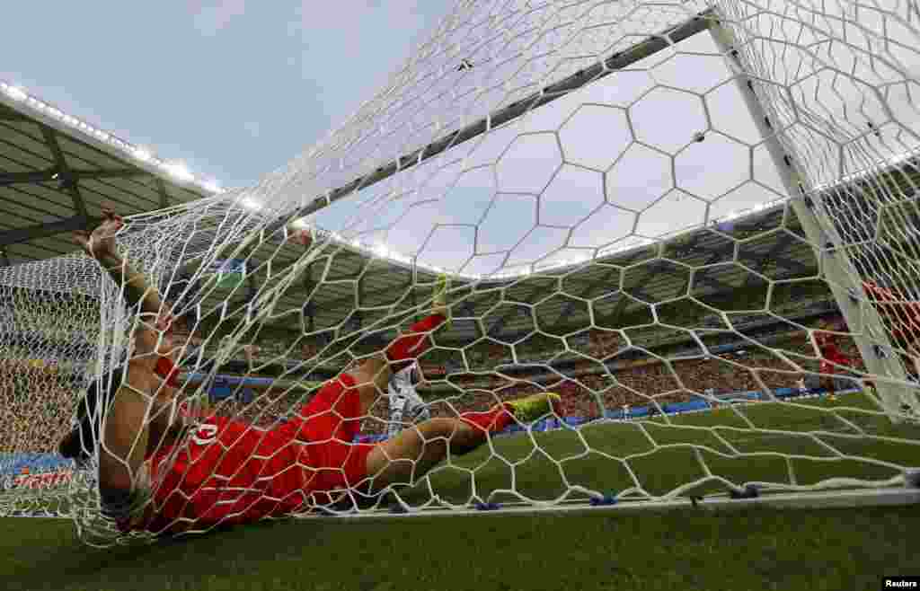 Swiss Ricardo Rodriguez ends up in the net after a save against Honduras at the Amazonia arena, in Manaus, June 25, 2014. 