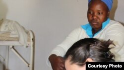 Stephanie Benn exercises a patient with cerebral palsy, as the child’s mother looks on (Photos:D.Taylor)