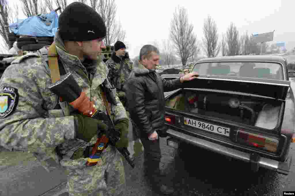 Members of the Ukrainian armed forces inspect a car at a checkpoint on the outskirts of Kostyantynivka, in the Donetsk region of Ukraine, Jan. 22, 2015.