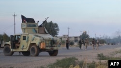 Iraqi pro-government forces stand guard on a road during a major operation against Islamic State fighters to retake the town and areas around Saadiya, northeast of Baghdad in Diyala province, Nov. 23, 2014. 